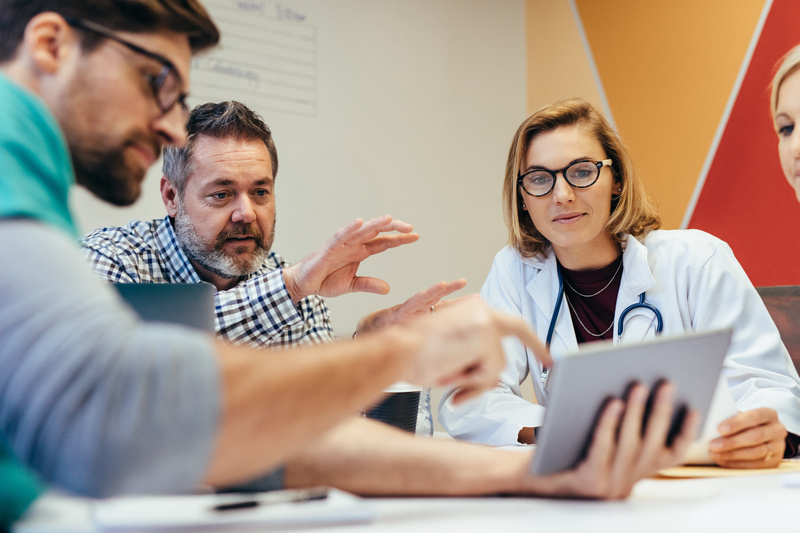 A group of health professionals sitting around a table discussing patient notes